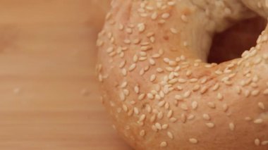 Tahta arka planda susam tohumlu taze pişmiş simit, video.