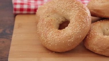 Tahta arka planda susam tohumlu taze pişmiş simit, video.