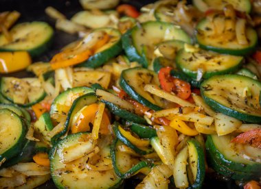 Bir plancha üzerinde kabak ve biber pişirmek.