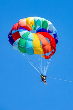 Sıcak hava balonu mavi gökyüzünde uçuyor.
