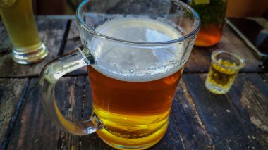 beer mug with foam on wooden table