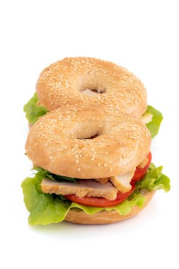 bagels with chicken and raw vegetables isolated on white background