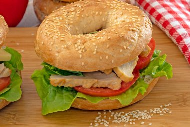 bagel with chicken and raw vegetables, close-up
