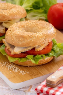 bagels with chicken and raw vegetables close-up