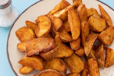 plate of wedge potatoes with paprika close up