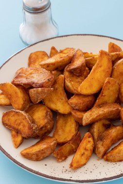 plate of wedge potatoes with paprika close up