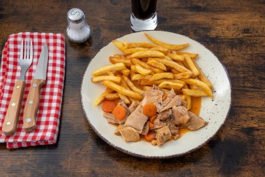 plate of tripe and fries on a table