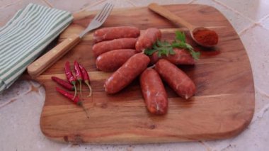 small raw chorizo sausages on a cutting board