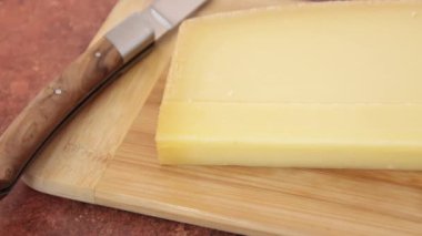 Kesme tahtasında bir dilim Comt peyniri