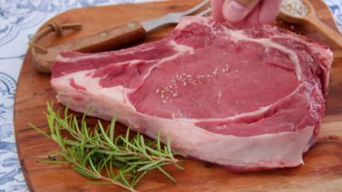 Adamın eli et kaburgasına tuz ve ot döküyor.