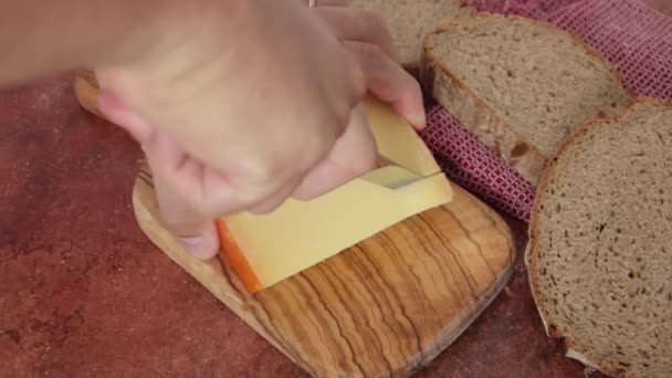 Männerhände Schneiden Ein Stück Gouda Käse — Stockvideo