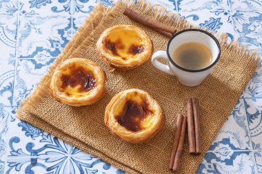 Pastel de nata ve bir fincan kahve yakın planda.