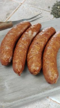 Kesme tahtasında çiğ sosis.