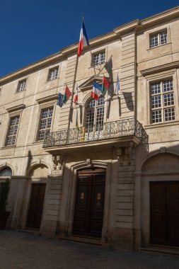 Mavi gökyüzünün altındaki Nmes Belediye Binası cephesi