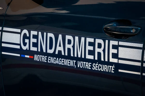 Kelime jandarması, güvenliğinize olan bağlılığımız bir arabanın yanında Fransızca yazılmış.