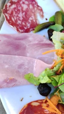 Bir tabak şarküteri ve çiğ sebze.