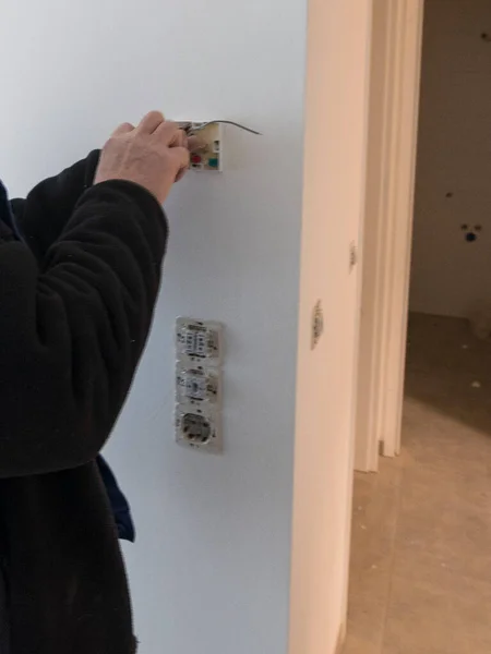an electrician installing or repairing electric, and pulling cables in a building