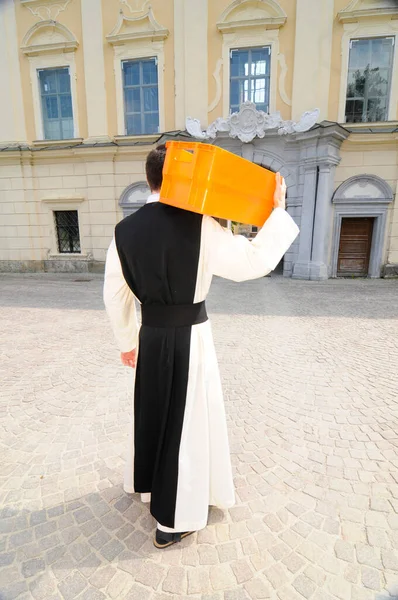 Pai Cisterciense Andando Com Uma Caixa Correio Laranja Seu Ombro — Fotografia de Stock