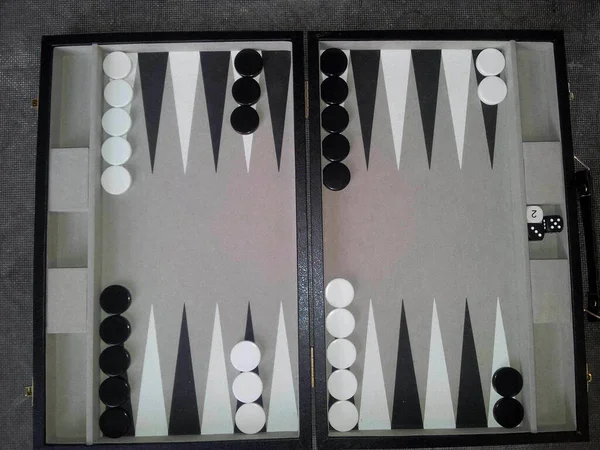 backgammon board with tokens and dice, playing a game of backgammon