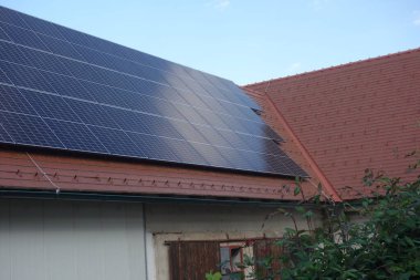 Modern binalarda yenilenebilir enerji kullanan bir evin çatısındaki güneş panelleri.