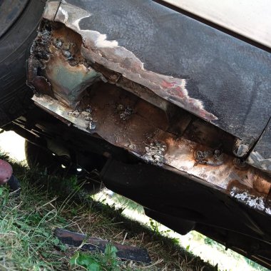 Araç gövdesinde pas, arabada aşınma izleri.