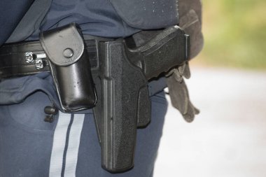 a police officer in police uniform with his service weapon