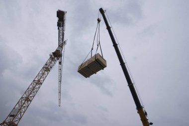 İnşaat alanında ağır yük taşıyan vinç.