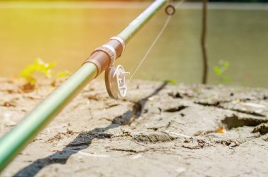 Nehir kıyısındaki tezgahta oltayla olta