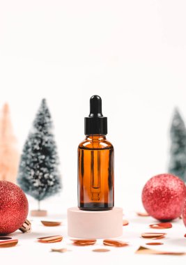 Noel arkaplanındaki temel yağ ya da serum şişesi. Noel satışları için boş. Kozmetik ve vücut bakımı
