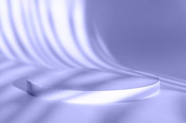 Kozmetik ürünlerin sunumu için podyum. Yılın çok Peri renginde bir palmiye ağacının gölgesiyle büyük yuvarlak bir reklam standı. Kozmetik ürün sunumu ve sergileri için podyum düzeni