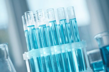 Laboratuvar mataraları ve deney tüpleri bilim laboratuarındaki masada.