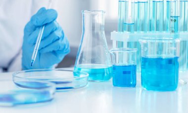 Laboratuvar pipeti bir bilim adamının elindedir. Bir bilim adamı koronavirüse karşı bir aşı üzerinde araştırma yapıyor. Laboratuvar klinik denemeleri.