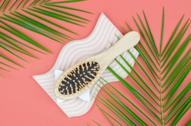 Geometrik bir podyumda ahşap tarak. Doğal malzemeden yapılmış tarak. Sıfır atık, plastik yok