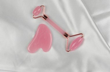 Beyaz ipek arka planda yüz masajcısı. Cilt bakımı