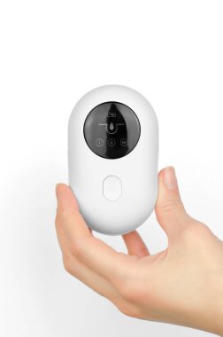 Blackhead remover in a female hand on a white background. Device for removing blackheads from facial skin