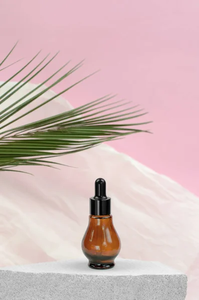 Natural essential oil or serum in a bottle with a pipette on a gray podium. Natural hyaluronic serum in bottles with a pipette
