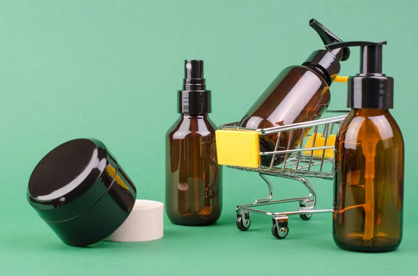 棕色化妆品瓶绿色背景 有选择的焦点 化妆品的网上购物概念 — 图库照片
