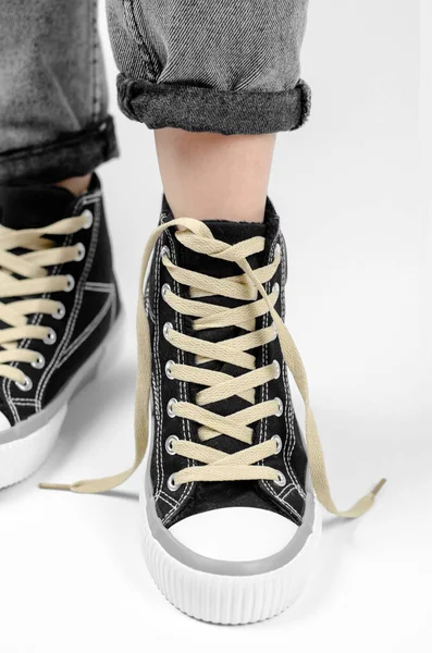 Sneaker Mit Ungebundenen Schnürsenkeln Auf Einem Weiblichen Bein Auf Weißem — Stockfoto