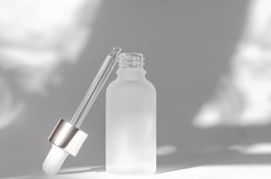 Beyaz arka planda gölgeli, esaslı yağlı beyaz kozmetik şişesi. Kozmetik marka modeli. Cilt bakımı kavramı