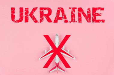 Üzerinde UKRAINE yazan pembe arka planda üstü çizilmiş bir oyuncak uçağın üst görüntüsü. Eyalet üzerindeki uçuşlara yasak
