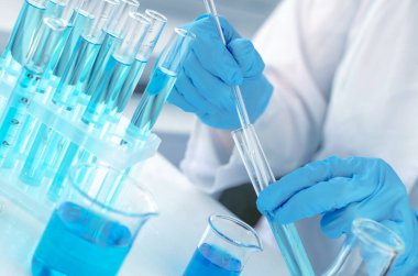 Laboratuvar pipetli bir bilim adamının elleri. Kimyasal deneyler için ekipman. Laboratuvar araştırması yapan bir bilim adamı.