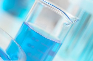 Bilimsel laboratuvar araştırmaları ve deneyleri. Mavi sıvılı laboratuvar şişesi. Yakın çekim, seçici odak..