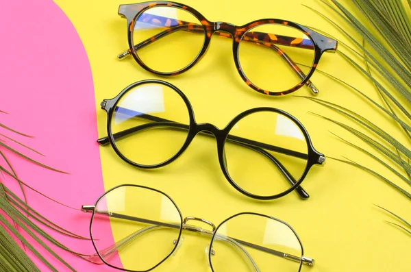 Snygga Glasögon Färgad Bakgrund Med Palmblad Uppsättning Glasögon Selektivt Fokus — Stockfoto