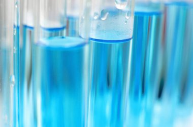 Mavi sıvılı laboratuvar test tüpleri. Yakın çekim, seçici odaklanma. Bilimsel laboratuvar araştırmaları ve deneyleri.