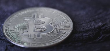 Koyu, ahşap bir yüzeyde gümüş bitcoin para, seçici bir odak. Dünya kripto para birimi