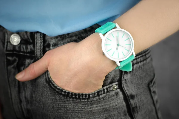 Stylish green wrist watch on a female hand, close-up