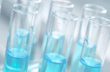 Mavi sıvılı laboratuvar test tüpleri. Yakın çekim, seçici odaklanma. Bilimsel laboratuvar araştırmaları ve deneyleri.