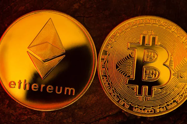 Ahşap bir yüzey üzerinde altın ethereum ve bitcoin sikkeleri - Ukrayna, İzmail, 17.03.2022
