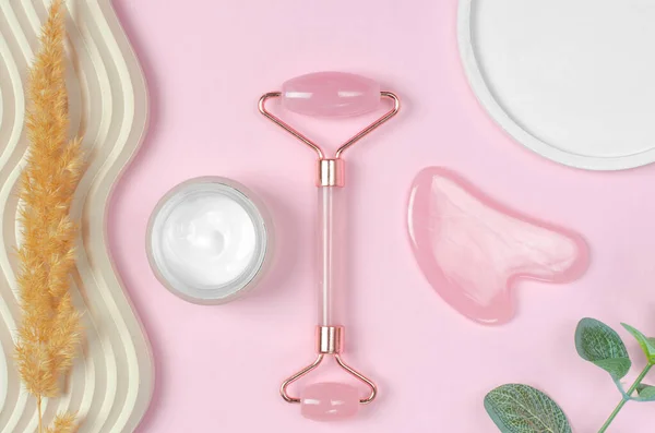 Roller Jade Gesichtsmassagegerät Und Offenes Glas Feuchtigkeitscreme Auf Rosa Hintergrund — Stockfoto