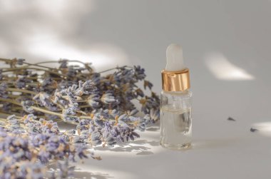 Lavanta yağı ve taze lavanta çiçekleriyle şeffaf şişe.